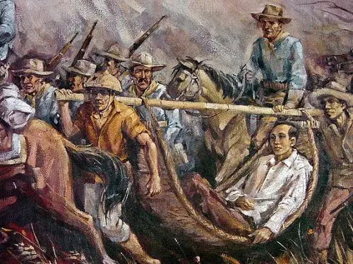 Apolinario Mabini resting in a hammock as men took turns at carrying him.